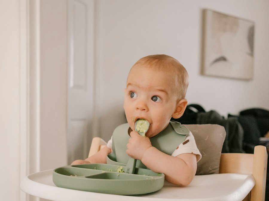 Baby in a high chair eating finger food