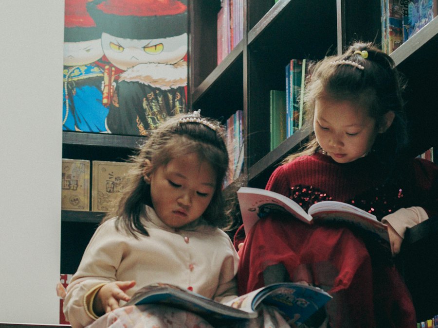 Two young girls reading books